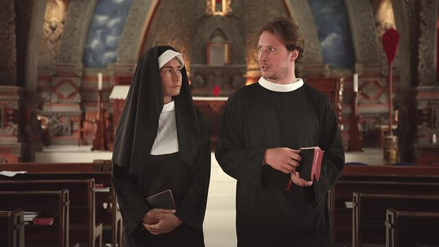 Nun and Clergyman Walking Inside Church before Prayer. Man and Woman Talking in Church about Religion Faith. Young Adult Pope and Sister Talk about God Together Indoors Chapel. Talk about Bible 4k