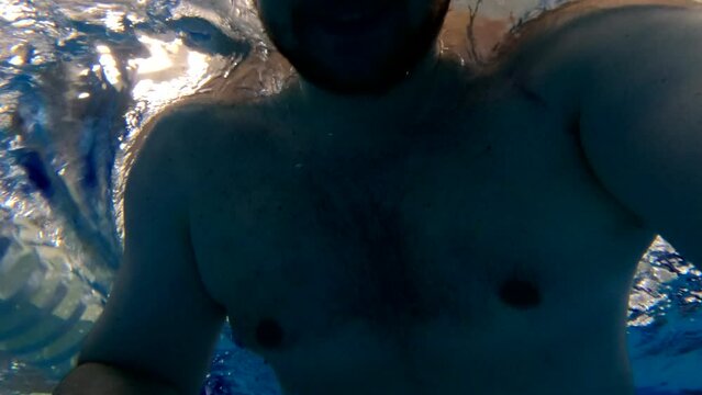 man taking selfie swimming in pool