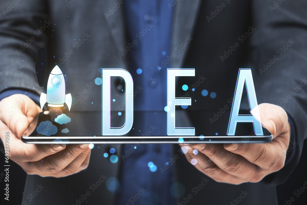 Poster close up of businessman hand holding pad with creative text with space ship replacing letter on blur