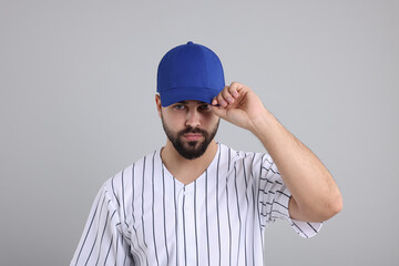 Man in stylish blue baseball cap on light grey background