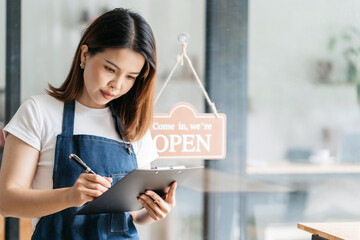 Opening a small business, Happy Asian woman in an apron standing to take orders, Small business...