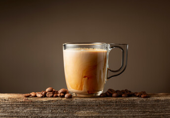Glass cup of coffee drink, latte or mocha on a brown background.