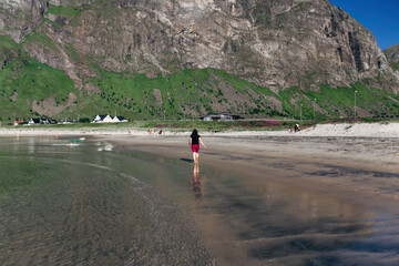 Woman walking on a beach, in Northern Norway