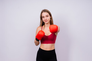 Woman boxer in gloves training on grey and yellow background
