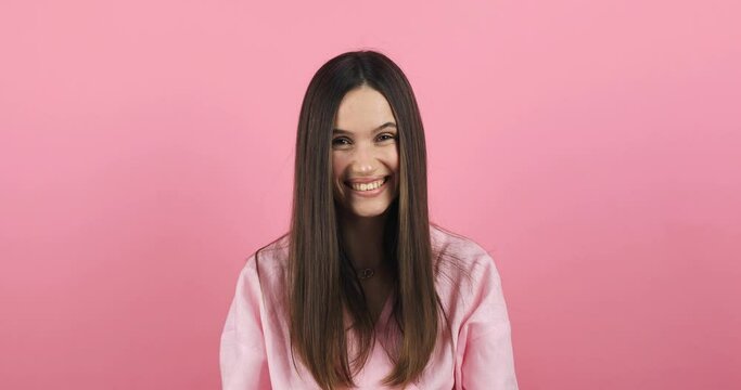 Amazed excited woman hairstyle in pink dress open mouth in surprise looking at camera with big eyes, shocked isolated on pink background. Oh my god wow, yes gesture, win symbol. 