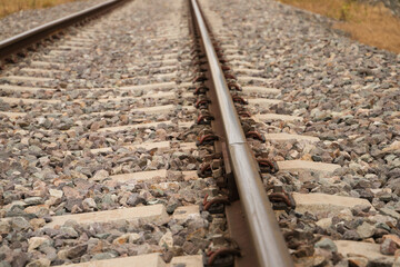 Detail of the rail of the railway track, stones, screw and wooden sleepers. Concept of means of transport.
