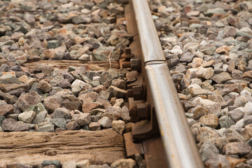 Detail of the rail of the railway track, stones, screw and wooden sleepers. Concept of means of...