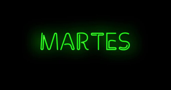 Flashing neon green Spanish Martes sign on black background on and off with flicker