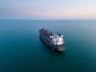 A massive cargo ship wood chips carrier in the sea, aerial view