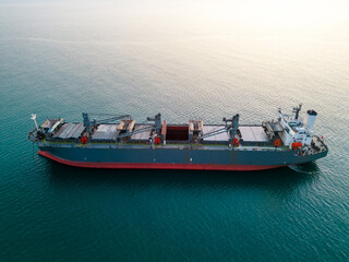 A massive cargo ship wood chips carrier in the sea, aerial view