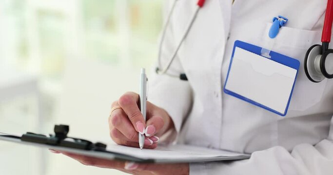 Closeup of medical professional hands composing medical letter or form