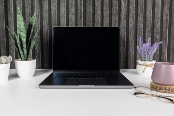 An elegant laptop adorns the desk, exuding sophistication. Perfect for banners promoting modern technology or sleek office accessories. 