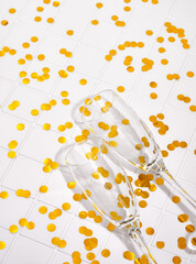 Two glasses lay on the surface with gold confetti. The end of the party.