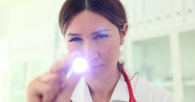 Portrait of doctor or nurse using flashlight for a medical examination
