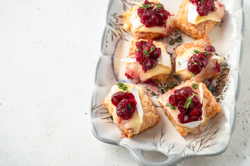 Holiday appetizers puff pastry with cranberry sauce, brie cheese and thyme