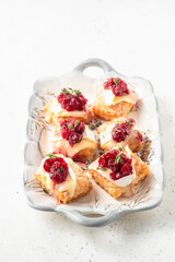Holiday appetizers puff pastry with cranberry sauce, brie cheese and thyme