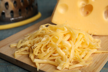 Tasty grated cheese on wooden table, closeup