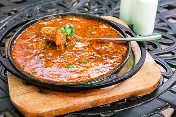 travel to Georgia - eating of Georgian dish Ostri (stewed pieces of meat in sauce with Georgian...