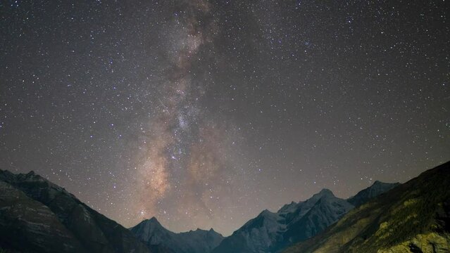 4K shot of Milkyway moving over snow covered mountains in Lahaul, India. Night time lapse. Starry night background. The Milky Way Galaxy moving over the Himalayas mountain ridge