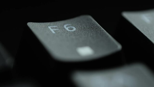 Keyboard button F6. Macro shot of finger pressing F6 button