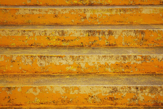 Old stairs painted with yellow paint. Artistic background.