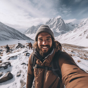 Man take a selfie picture by smartphone, traking in mountains. Cold weather, snow on hills. Winter hiking in mountains, tourism vacation concept