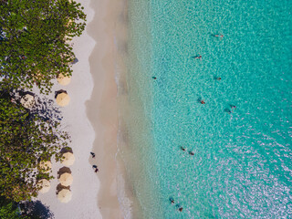 Koh Samet Island Thailand,people swimming in the ocean view from above at the Samed Island in Thailand with a turqouse colored ocean and a white tropical beach from above drone view