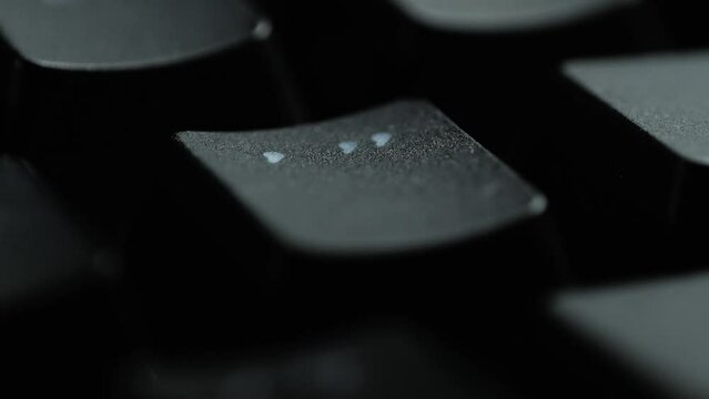 Keyboard button APOSTROPHE. Macro shot of finger pressing COLON button