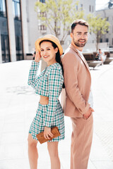 Beautiful fashion woman and her handsome elegant boyfriend in beige suit. Sexy brunette model in summer clothes. Fashionable smiling couple posing in street Europe. Brutal man and female outdoors