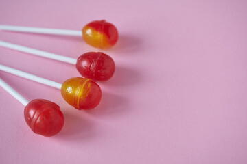 Lollipops on a pink background with space for text. Selective focus.
