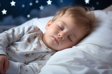 A small child sleeps in bed on a white background. Sweet, restful dreams. A little boy sleeps in pajamas in his bad