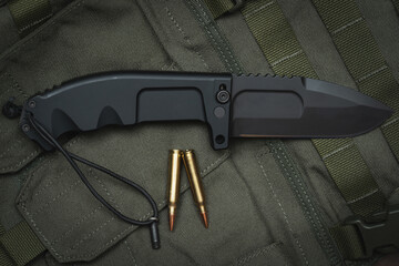 Large folding tactical survival knife and rifle ammo.