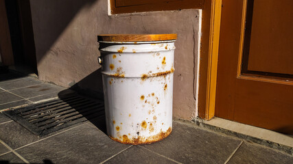 Rusty bucket in front of home