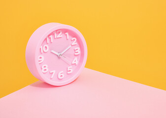 Round pink clock. Copy space for text. Time management concept.