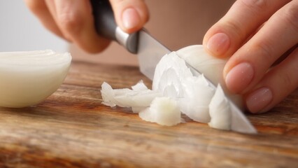 Close-up shot of hands finely dicing an onion. Shallow dof.