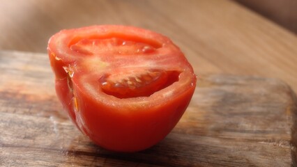 Peeled Fresh Tomato Half on Wooden Surface. Close-up, shallow dof.