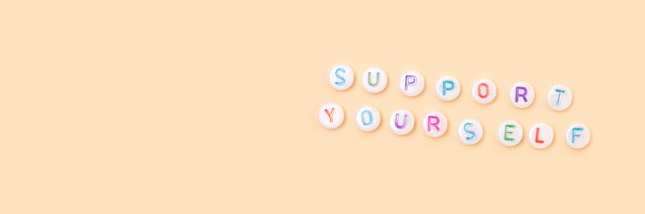 Support yourself. Banner with quote made of beads with letters on a beige background. Selfcare...