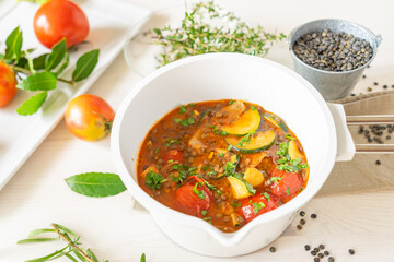 gemüsesauce im weißen topf zucchini tomaten