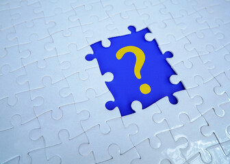 Question mark on jigsaw puzzle on blank background. Concept of question, faq, q&a, confusion and...