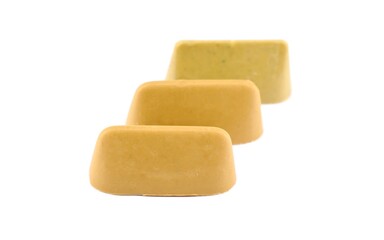 Three pistachio-flavored Gianduiotto on a white background. It'is a chocolate originally from Piedmont, in Northern Italy.