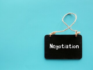 Chalkboard on blue background with text written NEGOTIATION - strategic discussion of two or more...