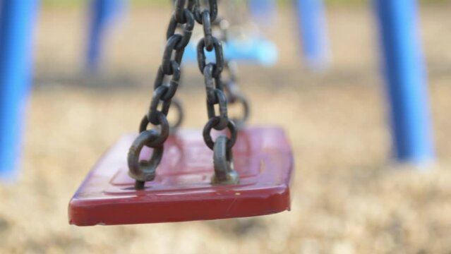 Empty swing swinging on a playground, concept of child abduction or kidnapping