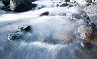 close up of water flowing over cobblestone in river
