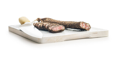 Obraz premium Smoked dried sausage. Sliced sausage on cutting board isolated on white background.