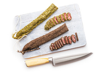 Smoked dried sausage. Sliced sausage on cutting board isolated on white background.