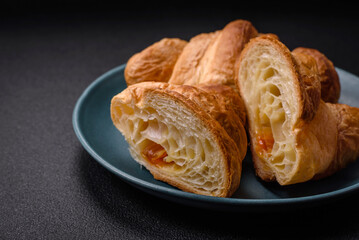 Delicious crispy baked sweet croissants with filling on a ceramic plate