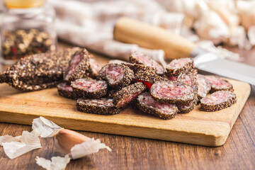 Smoked dried sausage. Sliced sausage on cutting board.