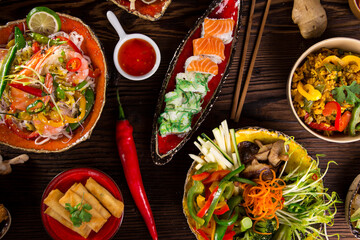 Assorted Asian food set. Chinese noodles, fried rice, dumplings, peking duck, dim sum, spring rolls. Famous Chinese cuisine dishes on table. Top view