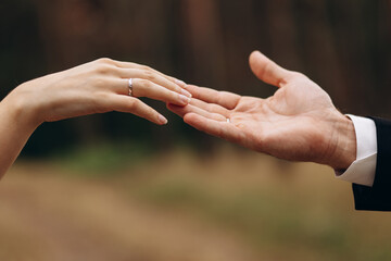 Hands of couple on their wedding day, female hand with engagement ring