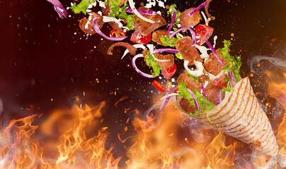 Close-up of kebab sandwich with flying ingredients. Freeze motion.